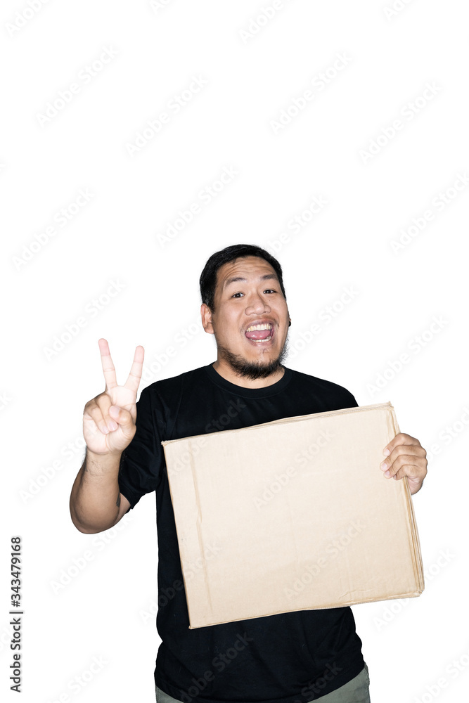 Bearded asian men worker dressed in black tees is holding cardboard and showing victory sign in white background.The concept of protest. Place for text or copy space. Clipping path. Bearded asian men worker dressed in black tees is holding cardboard and showing victory sign in white background.The concept of protest. Place for text or copy space. Clipping path.