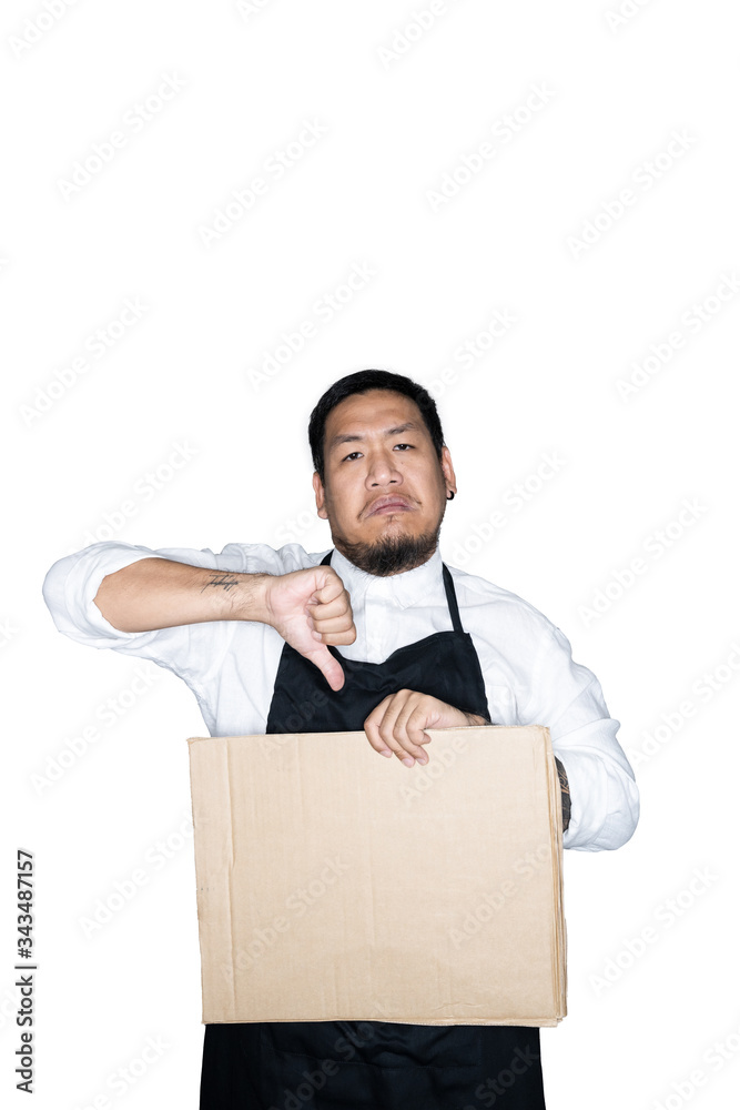 Bearded asian men waiter, chef dressed in black apron is holding cardboard and showing thumbs down in white background.The concept of protest. Place for text or copy space. Clipping path. Bearded asian men waiter, chef dressed in black apron is holding cardboard and showing thumbs down in white background.The concept of protest. Place for text or copy space. Clipping path.