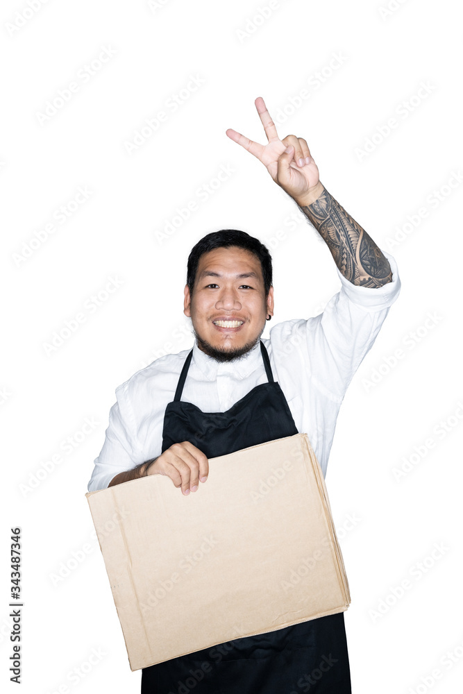 Bearded asian men waiter, chef dressed in black apron is holding cardboard and showing victory sign in white background.The concept of protest. Place for text or copy space. Clipping path. Bearded asian men waiter, chef dressed in black apron is holding cardboard and showing victory sign in white background.The concept of protest. Place for text or copy space. Clipping path.
