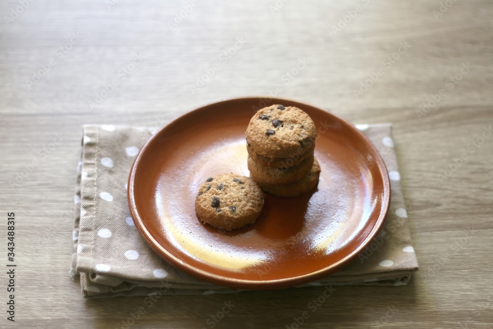 Chocolate chip cookies and polka dot napkin on wooden table. Selective focus. Chocolate chip cookies and polka dot napkin on wooden table. Selective focus.