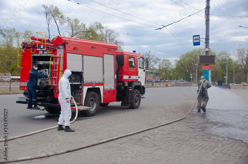 The savior of the fire service disinfects the streets of the city. Preventive methods against coronavirus. Specialist in hazmat suits cleaning disinfecting coronavirus cells epidemic, pandemic health  photo