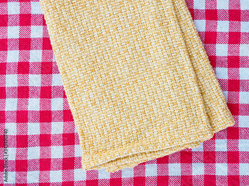 Cotton textile napkin on the red gingham textile 