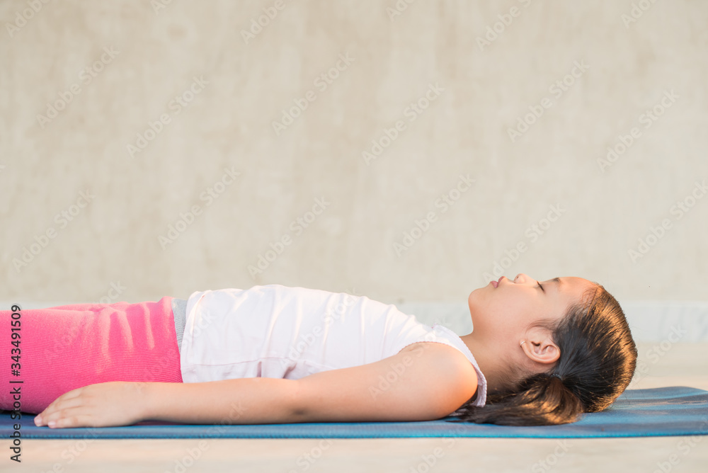 calmness and relax, female freedom happiness. home practice room background. little asian girl meditates while practicing yoga. child happiness. toned picture healthy life. yoga concept. calmness and relax, female freedom happiness. home practice room background. little asian girl meditates while practicing yoga. child happiness. toned picture healthy life. yoga concept.
