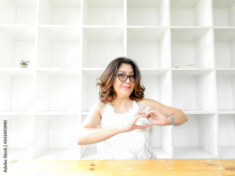 Beautiful woman smiling happy against white background with wood table Beautiful woman smiling happy against white background with wood table