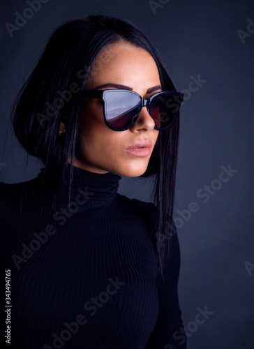 Attractive brunette woman posing to camera with sunglasses