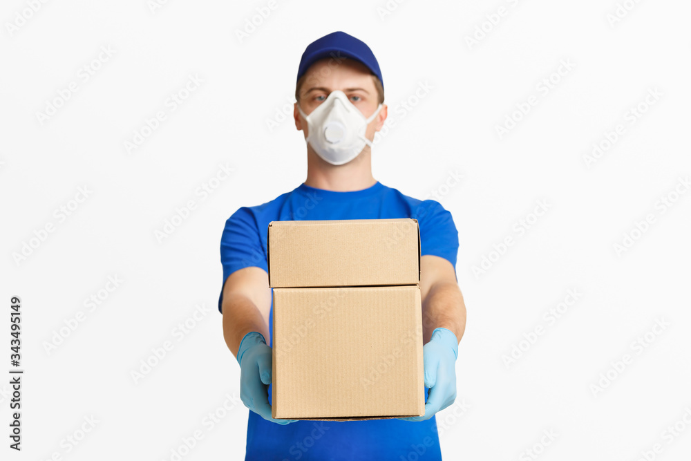 Stay home concept. Courier in protective mask, gives box Stay home concept. Courier in protective mask, gives box
