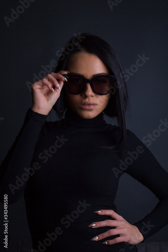 Attractive brunette woman posing to camera with sunglasses