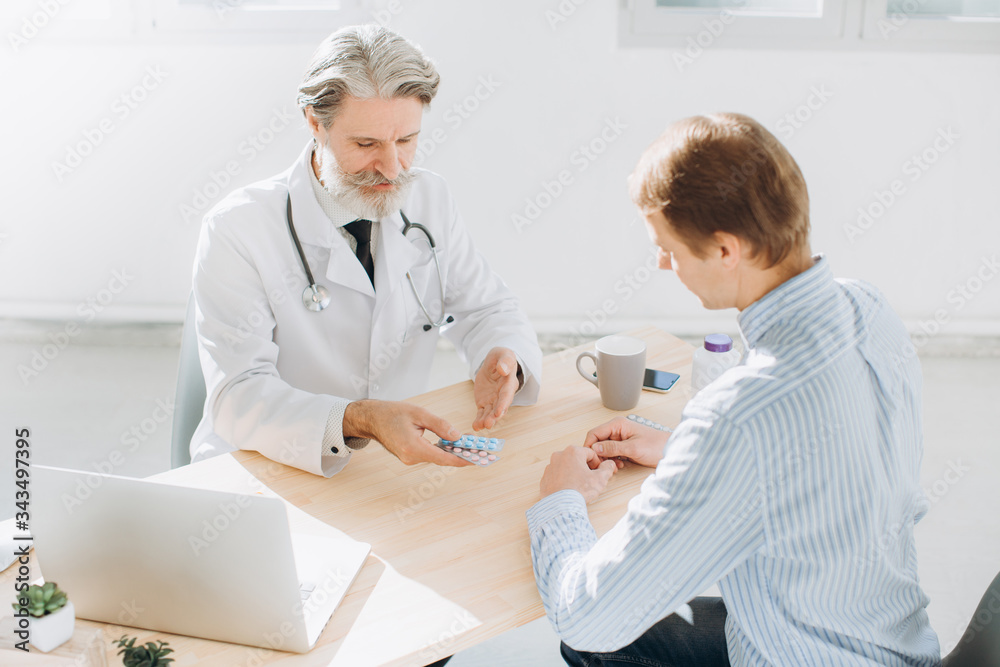 Fototapeta premium Patient Having Consultation With Senior Doctor In Office