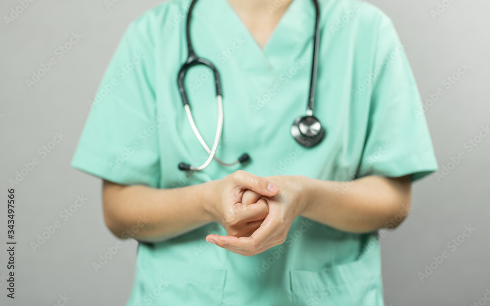 Nurse or Doctor in green uniform with stethoscope is demonstrating washing and cleaning hands and palm Nurse or Doctor in green uniform with stethoscope is demonstrating washing and cleaning hands and palm