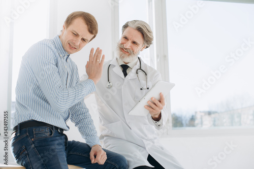 Patient Having Consultation With Senior Doctor In Office