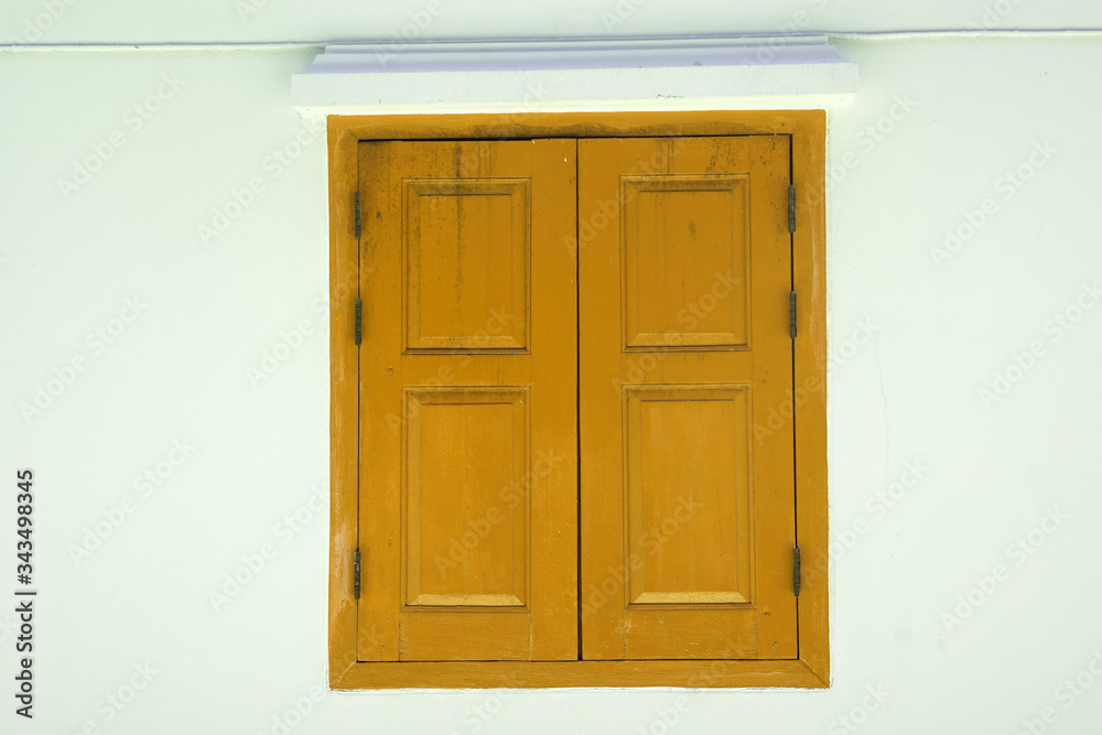 Yellow Wooden door on white wall texture background - abstract surface with copy space                                