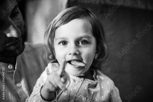 Little girl shows tongue and finger. black and white photo