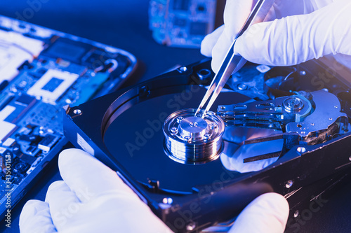 The abstract image of inside of hard disk drive on the technician's desk and a computer motherboard as a component. the concept of data, hardware, and information technology.