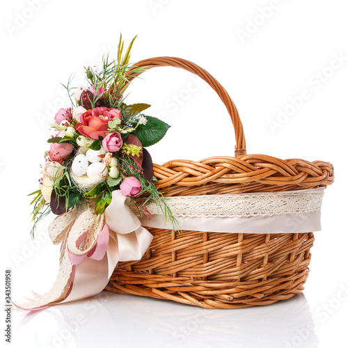 Natural wicker basket with flowers and ribbons. Beautiful bow on the side. Isolated