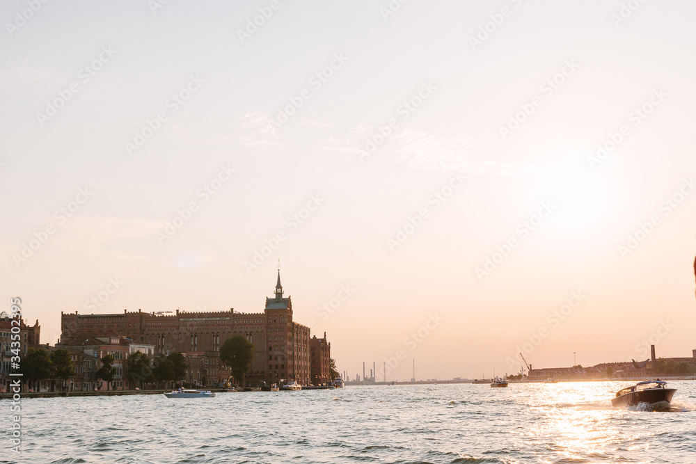 Holtel Hilton in Venice in summer time. Italian view. Sea canal, boat in sunny day. Old city, ancient buildings.  Italy. Popular tourist destination of Italy. Europe. Venetian canal without  people.