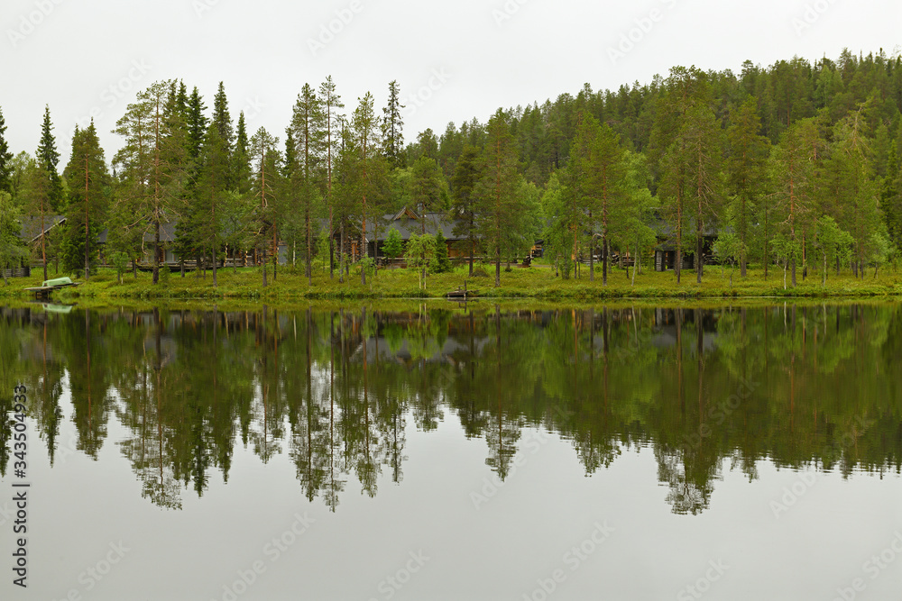 Northern landscape with forest lake and mirror reflection. Ruka, Finland