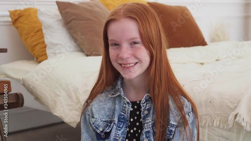 Teenage girl looking at camera and smiling at home
