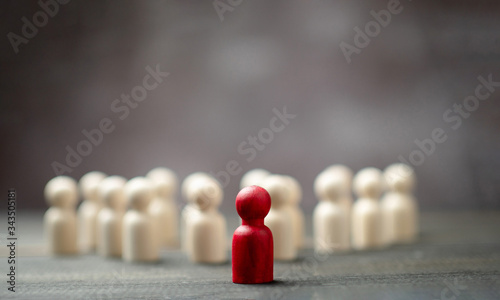 Wooden figure standing in front of the team to show influence and empowerment. Concept of business leadership for leader team, successful competition winner and Leader with influence