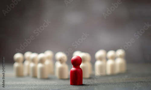 Wooden figure standing in front of the team to show influence and empowerment. Concept of business leadership for leader team, successful competition winner and Leader with influence photo