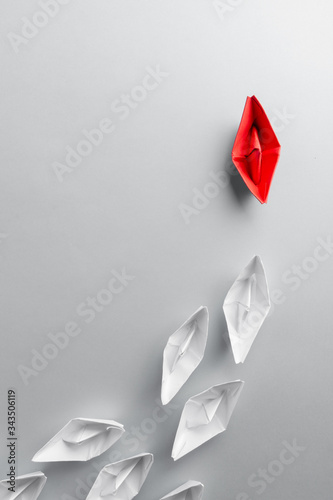 Leadership concept using red paper ship among white