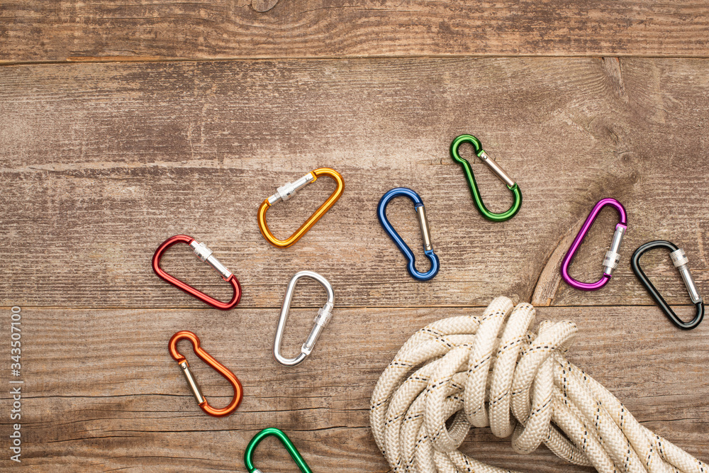 top view of colorful carabiners and hiking rope on wooden table top view of colorful carabiners and hiking rope on wooden table