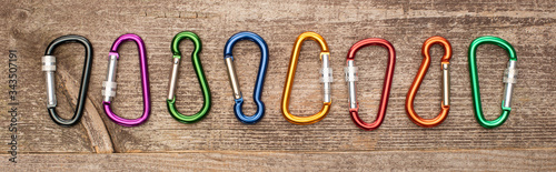 panoramic shot of colorful carabiners on wooden table