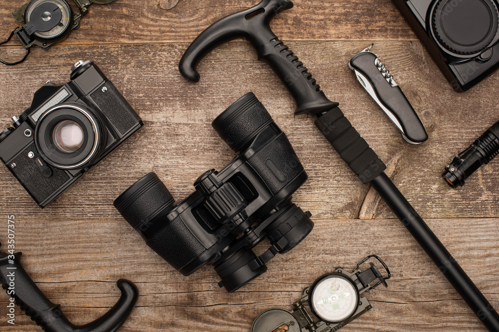 top view of hiking equipment and photo cameras on wooden surface top view of hiking equipment and photo cameras on wooden surface