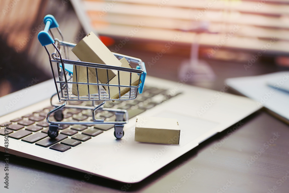 Online shopping concept. paper boxes in shopping cart on  Laptop Computer at home or office