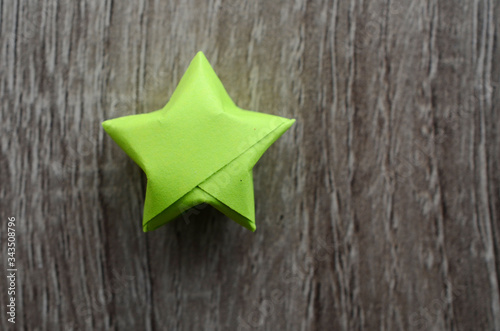 Green origami lucky stars on wooden