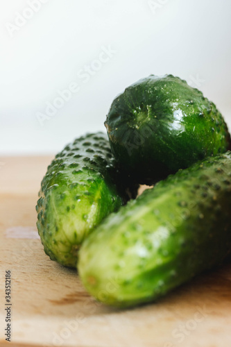 Fresh cucmbers on the wooden table with white background