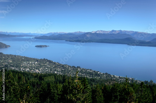 Landscape with lakes between mountains and pine trees. On top of a mountain in Bariloche  Argentina. A sunny summer day.
