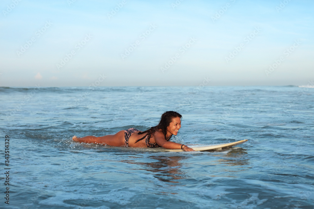 Sexy Surfer. Surfing Girl In Bikini On White Surfboard In Ocean. Tanned Brunette Swimming In Sea. Water Sport As Hobby.