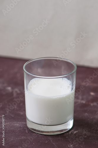 One glass of milk on brown background.