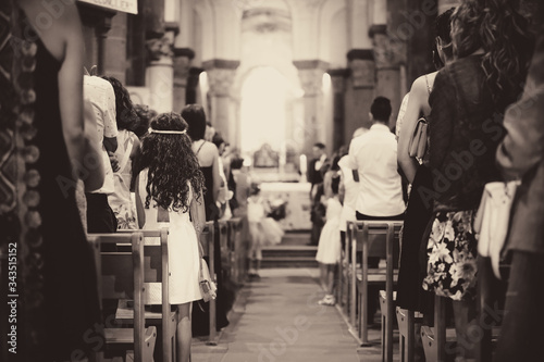 Cérémonie religieuse lors d'un mariage à l'église. Jeune fille debout et à l'écoute durant une cérémonie de mariage. Ambiance en noir et blanc.
