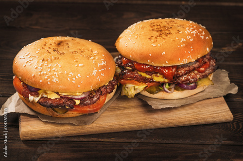 Two big homemade burgers or hamburgers with big roasted meat, close up.