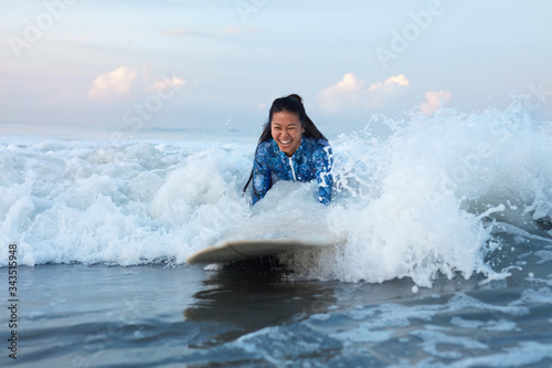 Beautiful Surfer Girl. Surfing Woman On Surfboard In Ocean. Smiling Brunette Swimming In Splashing Sea. Water Sport For Active Lifestyle.