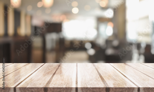 3D Rendering, Wooden top table with bokeh light effect and blur restaurant on background, blur background © DEEP PIXEL