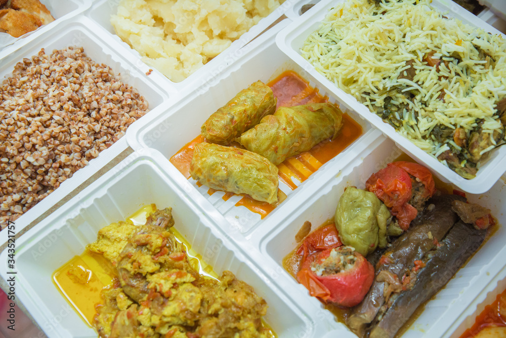 Delivery sets of healthy and delicious food in boxes . A variety of fast food in plastic boxes .
