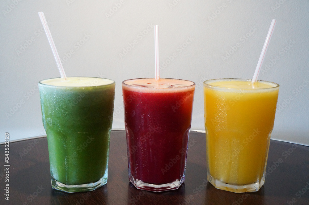 Healthy and colorful fruit juices. Green (pineapple with mint), red (apple, watermelon, strawberry) and yellow (orange, tangerine) Healthy and colorful fruit juices. Green (pineapple with mint), red (apple, watermelon, strawberry) and yellow (orange, tangerine)