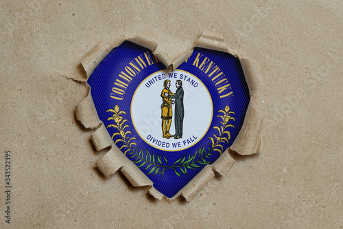 Heart shaped hole torn through paper, showing Kentucky flag