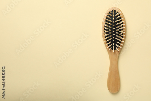 Hair brush on beige background, space for text