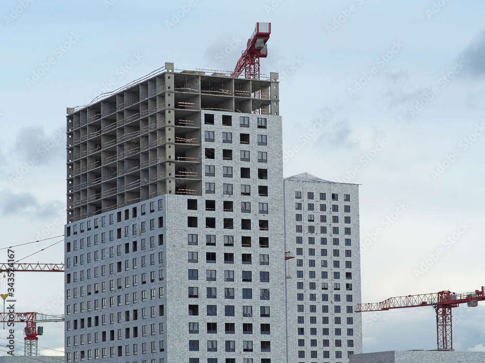 Fototapeta premium The construction of a skyscraper with a crane. New buildings, industry, construction