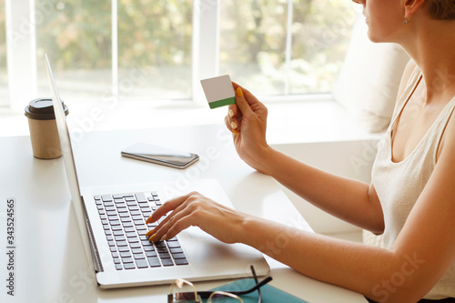 Picture of close up woman   s hands with credit card making shopping at laptop