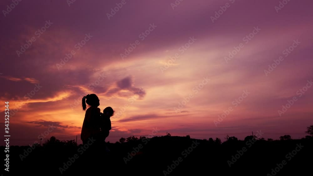 silhouette of mother holding her son above her head as slow motion short silhouette of mother holding her son above her head as slow motion short