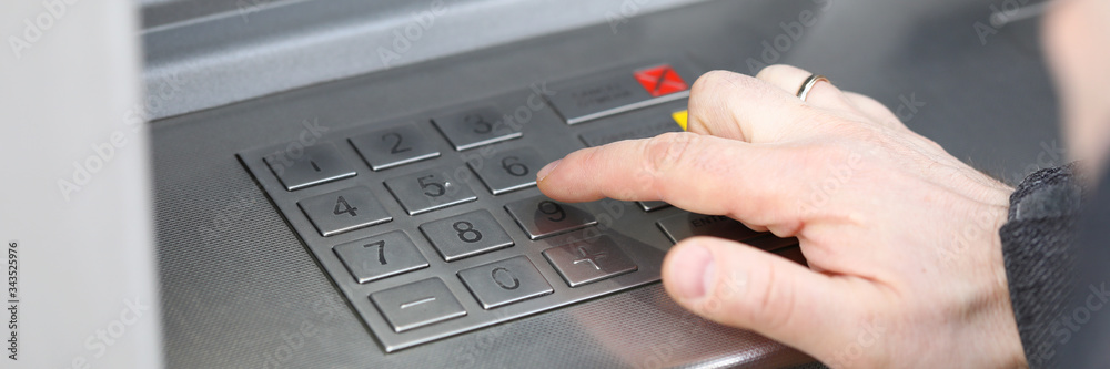 Closeup male hand dials pin code on terminal Closeup male hand dials pin code on terminal