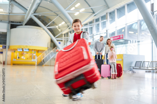 Boy plays with a rolling suitcase in the waiting time