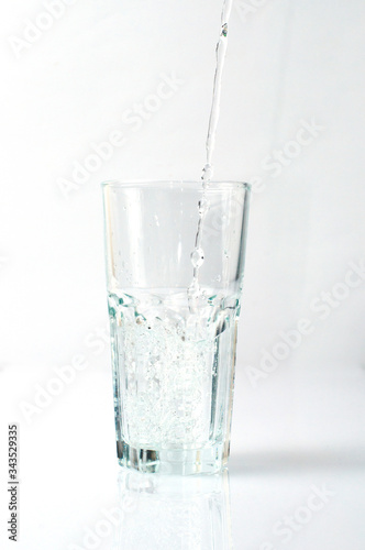 Splashing liquid, water is pouring into a glass