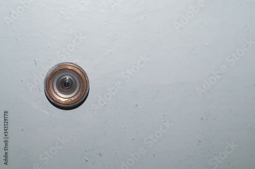 Old peephole on a painted wooden door