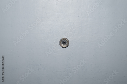 Old peephole on a painted wooden door