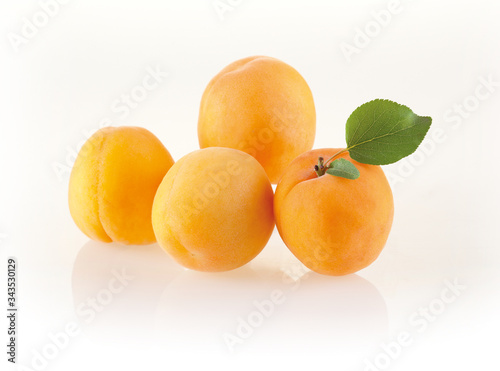 Fresh apricots with leaves isolated on white background